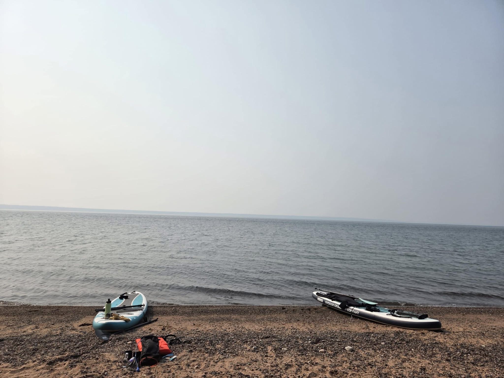 Two paddleboards on a quiet beach beside Lake Superior